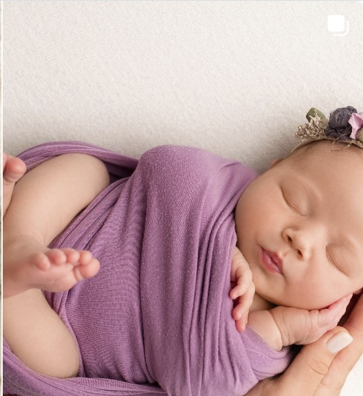 Newborn wrapped in purple